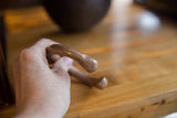 Handcrafted antique copper cuff bracelet held to demonstrate its substantial feel and size.