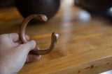 Antique African copper snake cuff held in hand to show its solid form and patina.
