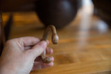 Antique copper snake cuff bracelet held in hand, showing its scale and open C-shape.