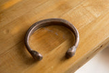 Aged copper patina and engraved markings on a collectible African bracelet.
