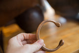 Hand-etched geometric and circular details on an antique copper snake cuff.
