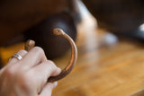 Stylized snake head terminal and etched details on the antique copper cuff bracelet.