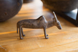 Side view of a vintage African bronze zebu showing its aged, handmade patina.