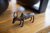 The characteristic profile of a vintage bronze zebu with a rustic, handmade texture.