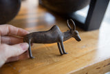 Vintage African bronze zebu held in hand, showing its rustic, handmade character.