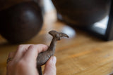 Close-up of the handmade bronze kori bustard's head showing textured details.