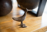 Side profile of a vintage African bronze bird showcasing its rustic handmade patina.