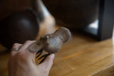 Detail of handmade markings and aged patina on the vintage bronze bird's tail.