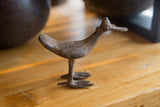 Vintage African bronze bird showing its aged, textured surface and flat bill in profile.