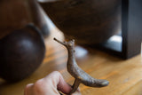 Vintage African bronze bird sculpture held in hand to show its collectible scale and profile.