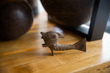 Styled view of a vintage African bronze fish highlighting its rustic handmade texture.