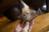 Vintage African bronze fish held in hand, showing its rustic handmade texture.