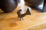 Etched scale patterns and aged patina on a vintage African bronze standing fish.