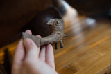 Close view of the hand-etched details and aged patina on a small bronze fish sculpture.
