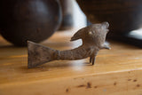 The rustic texture and hand-carved details of the vintage standing bronze fish sculpture.