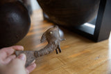 Hand holding the vintage bronze fish, highlighting its rustic patina and handmade details.