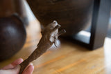 Close-up showing the textured, handmade details on a vintage African bronze fish head.
