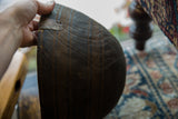 Vintage African wooden bowl side, displaying metal repair and deeply carved lines.