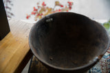 Vintage African wooden bowl detail, showing aged interior, metal repair, and textured wood.