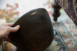 Vintage African wooden bowl with textured dark surface and visible crack.