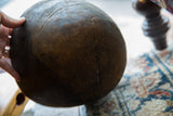 Dark brown vintage African wooden bowl with prominent surface crack.
