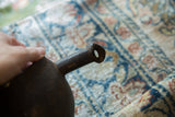 Close-up of the vintage African pitcher's unique spout and dark, textured wood.