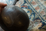Hand-carved details and a small chip showing the age of the wooden pitcher.