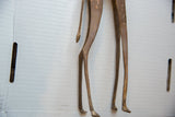 Slender hind legs and textured tail tip of a vintage handmade bronze alloy giraffe.
