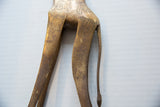Etched spot pattern and aged patina on the hindquarters of a vintage bronze giraffe.