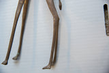 The aged patina and handcrafted form of the vintage bronze giraffe's legs.