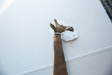 Close-up of the vintage bronze giraffe's head showing its ears and aged patina.