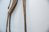 Aged texture on the slender tail and legs of a vintage bronze giraffe.