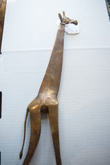 Overhead view of the vintage bronze giraffe's full length and textured surface.