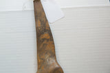 Aged bronze alloy showing a textured surface and mottled patina.
