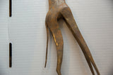 Aged patina on the handcrafted hindquarters of the vintage bronze alloy giraffe.