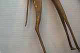 The sculpted form of the vintage bronze giraffe's slender hind legs and tail.