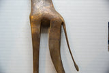 Detailed view of the vintage giraffe's hindquarters showing etched spots and thin bronze tail.