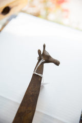 Close-up view of the vintage bronze giraffe's stylized head from an angle.