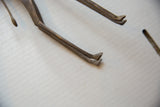 Detail showing the stylized hooves and slender tail of the handmade bronze giraffe.