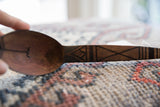 Carved symbol in the bowl and incised geometric patterns on the wooden spoon handle.