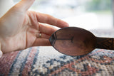 Incised linear designs inside the dark wood bowl of a vintage African spoon.