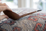 Aged patina and woodgrain visible along the side profile of the long African spoon.