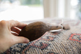 A hand holds the carved wooden spoon, showing its sculpted texture.