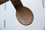 The warm, aged patina and texture inside the bowl of a vintage African wooden spoon.
