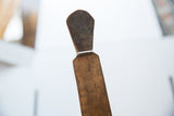 Detail of the vintage wooden spoon's dark, patinated head and handle.