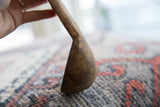 Angled view of the handmade wooden spoon's bowl, showing its aged and textured surface.