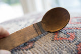 Close-up of carved details at the neck of a vintage African wooden spoon.