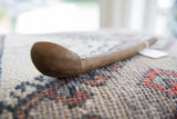 Detailed side view of the vintage African wooden spoon, highlighting the aged grain of the wood.