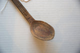 Hand-carved crosshatch and linear patterns on the vintage African wooden spoon.