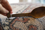 Hand-carved crosshatch pattern on the dark wood handle of a vintage Tuareg spoon.